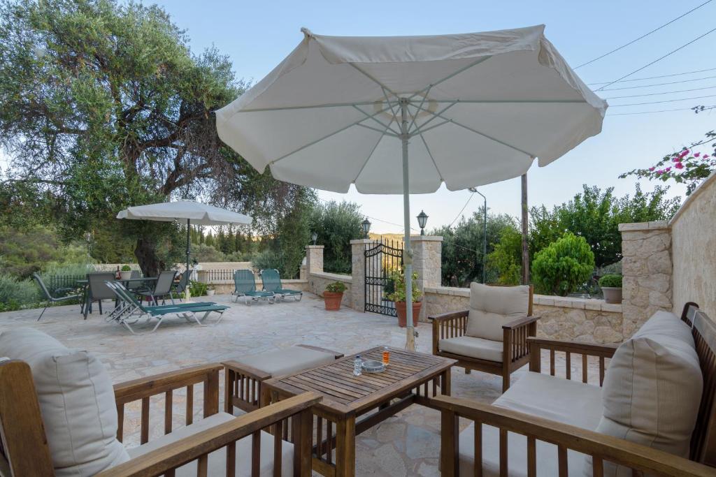 a patio with a table and an umbrella at Balis Apartments in Paleokastritsa