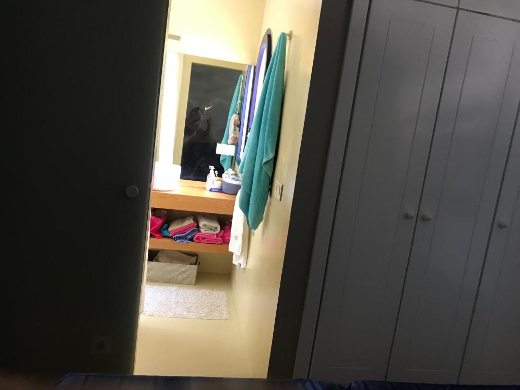 ein Badezimmer mit einem Spiegel und einem Schrank mit Handtüchern in der Unterkunft Meloneras in Meloneras
