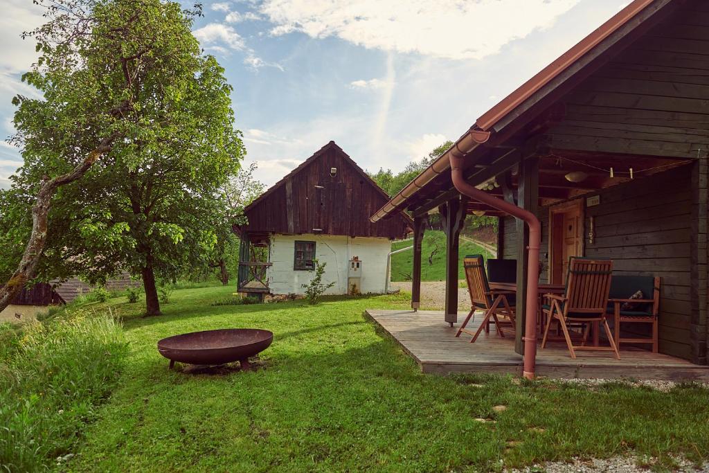 a porch of a barn with chairs and a table at Srčna, Tri Vile, a beautiful log cabin with amazing view in Podčetrtek