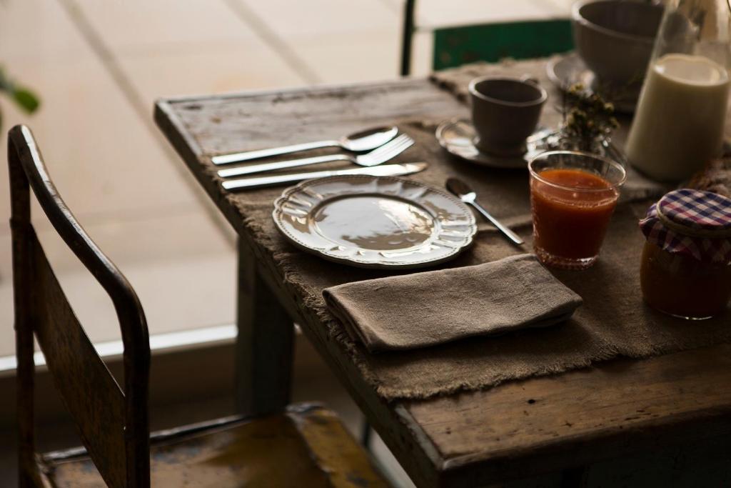 a wooden table with a plate and utensils on it at A Casa Di Ita in Villorba