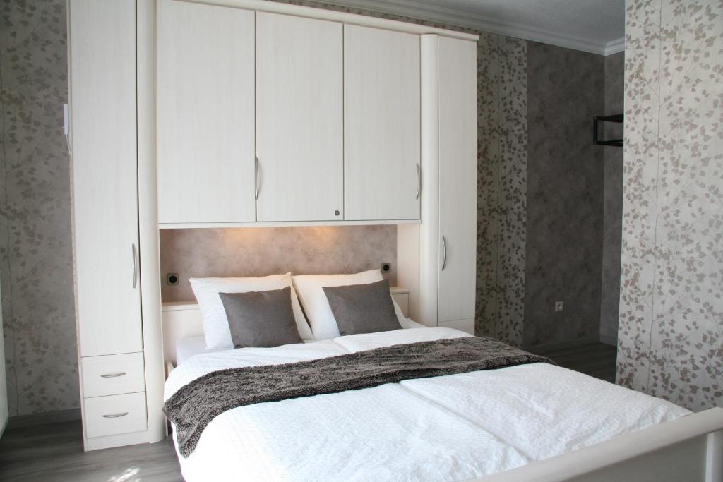 1 dormitorio con 1 cama grande y armarios blancos en Haus Luna, en Bütgenbach