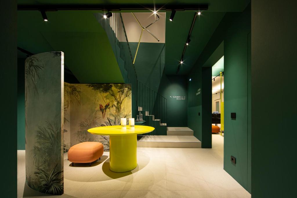 a room with a yellow table and a yellow stool at Elide Design Hotel in Assisi