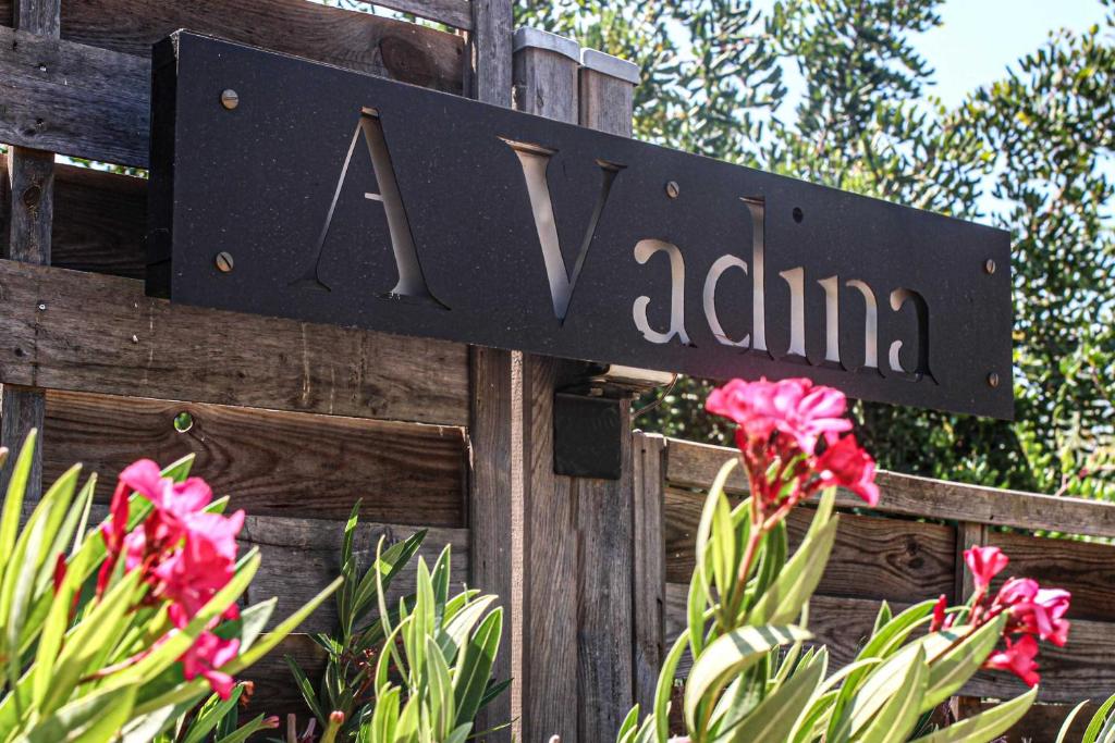 a sign on a wooden fence with pink flowers at Chambre d'hôtes A Vadina Porticcio in Porticcio