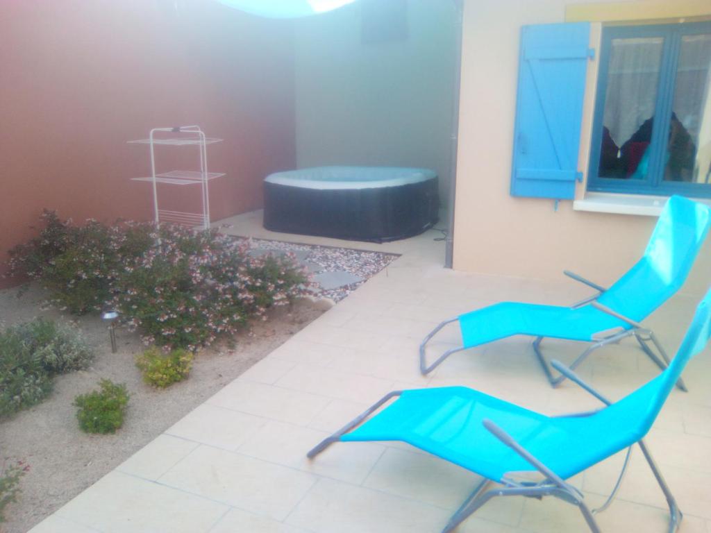 ein Paar blauer Stühle auf einer Terrasse in der Unterkunft Gîte chaleureux avec jacuzzi in Saint-Rabier