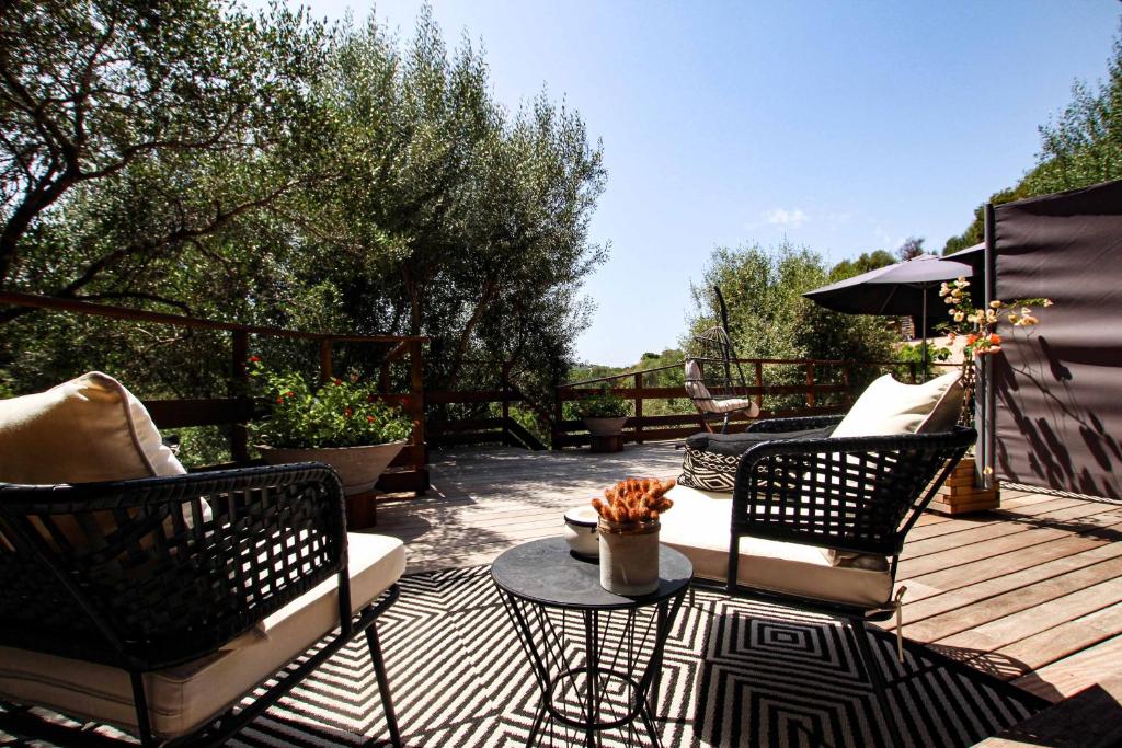 a patio with two chairs and a table on a deck at Chambre d'hôtes A Vadina Porticcio in Porticcio