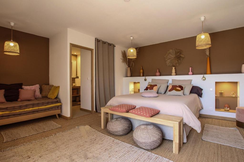 a bedroom with a large bed and a couch at Chambre d'hôtes A Vadina Porticcio in Porticcio