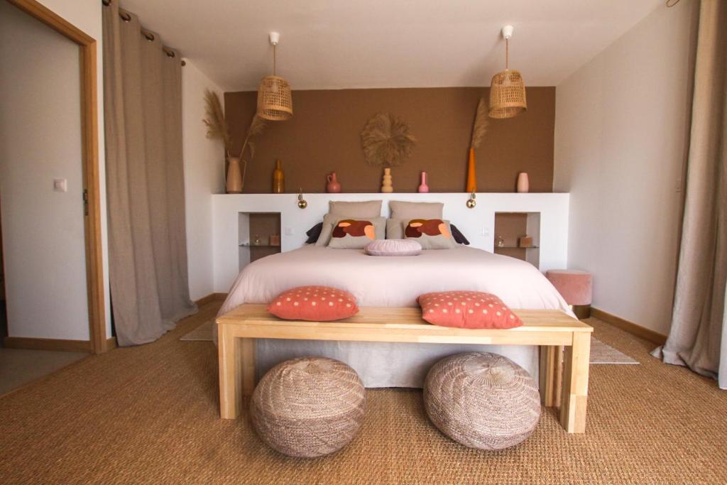 a bedroom with a bed with two ottomans on it at Chambre d'hôtes A Vadina Porticcio in Porticcio