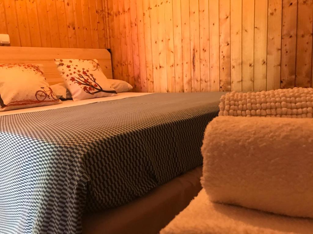 Cama en habitación con paredes de madera en Cabaña en la naturaleza 2, en Madrid