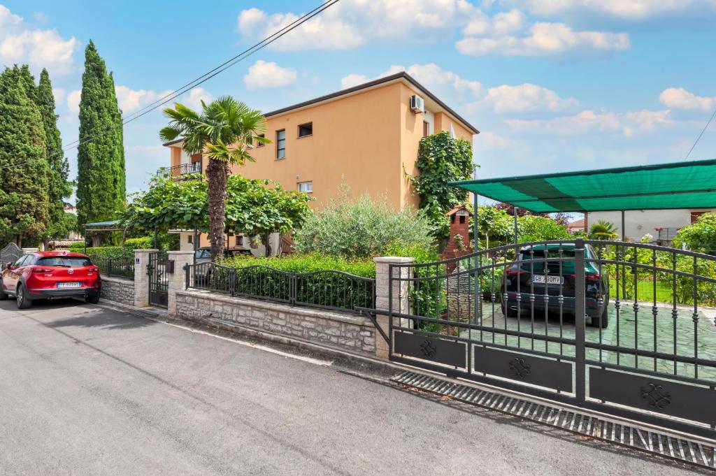 una casa con cancello e una macchina parcheggiata in strada di Apartment Casa Banko a Rovigno (Rovinj)