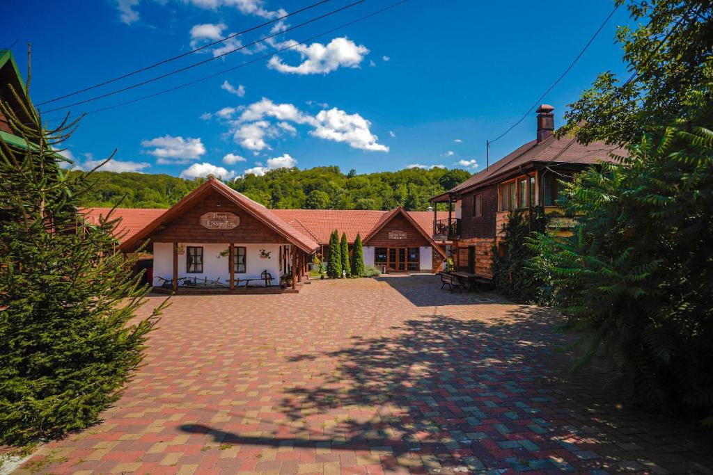 a building with a brick driveway in front of it at La Ferma Veche Bogdana in Bogdana