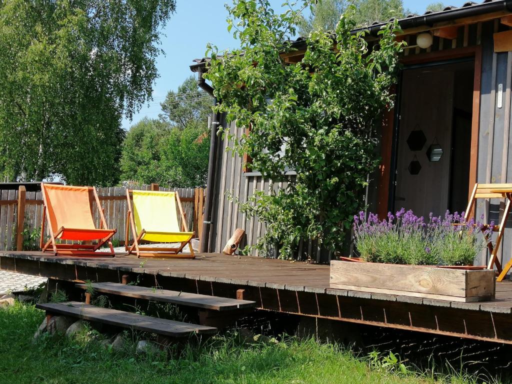 two chairs sitting on a deck next to a house at Wodamoja - apartamenty nad jeziorem in Stawiguda