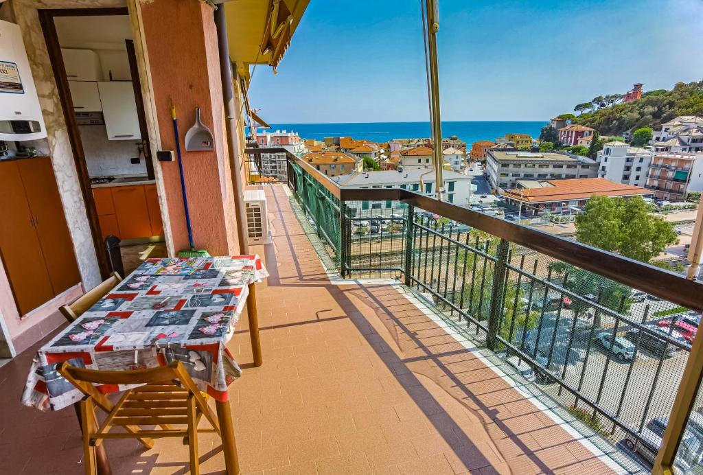 a balcony with a table and a view of a city at Luminoso appartamento vacanze vista mare in centro in Celle Ligure