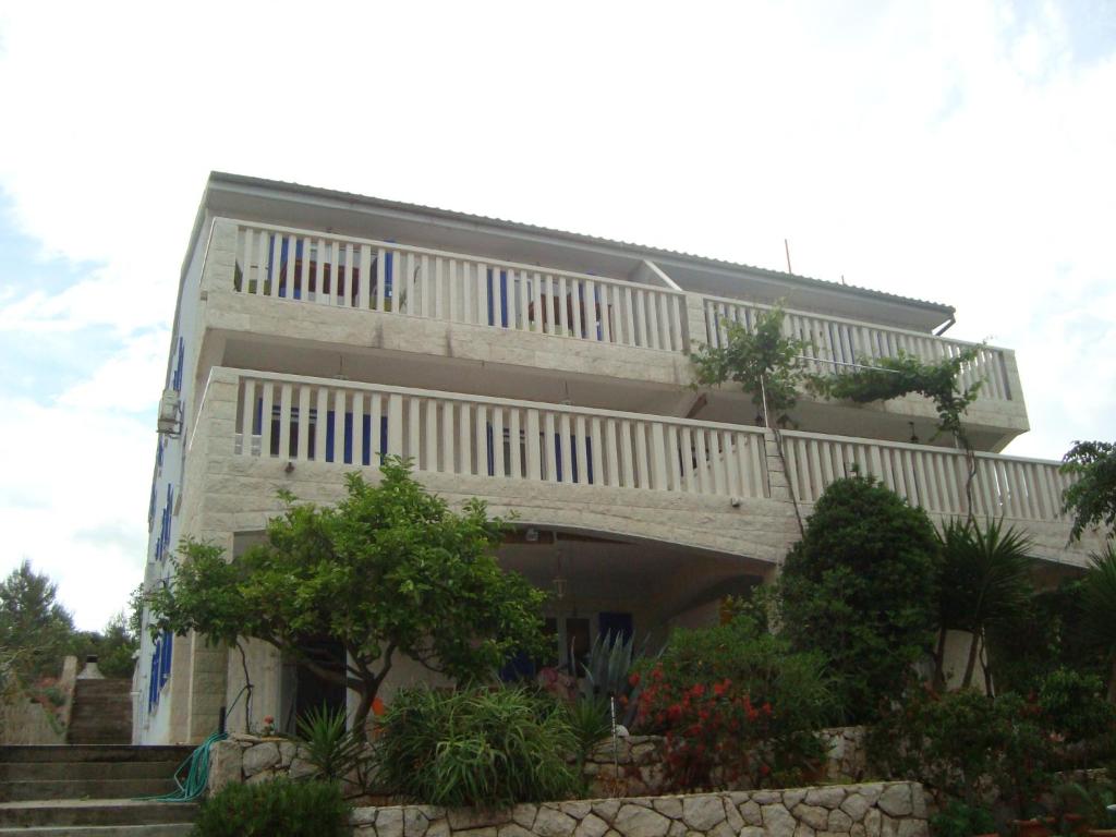 een wit gebouw met een balkon erboven bij Apartment SEA STAR in Hvar