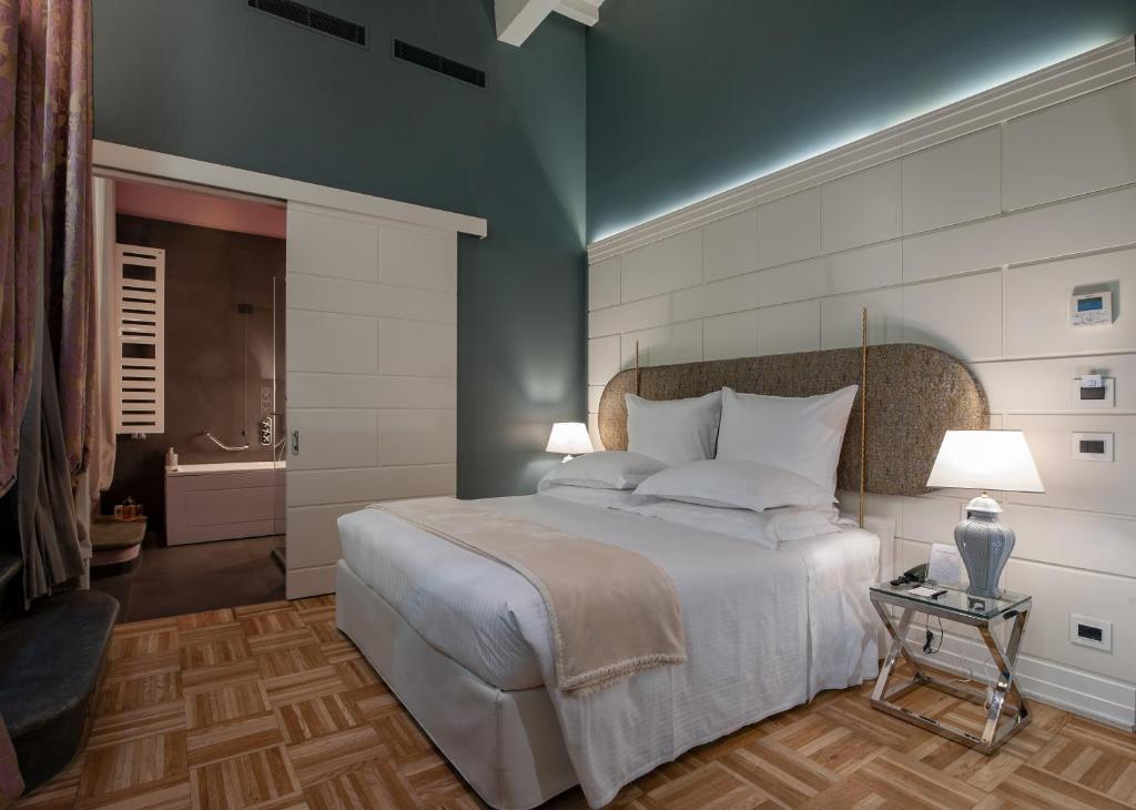 フィレンツェにあるHotel Number Nineのベッドルーム(大型ベッド1台付)、バスルームが備わります。