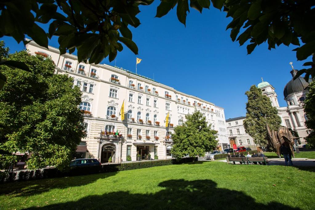 a large white building with a park in front of it at Hotel Bristol Salzburg in Salzburg
