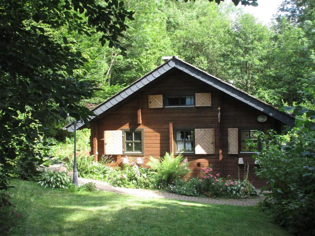 una pequeña casa de madera en medio de un patio en Ferienhaus Eulennest, en Hilders