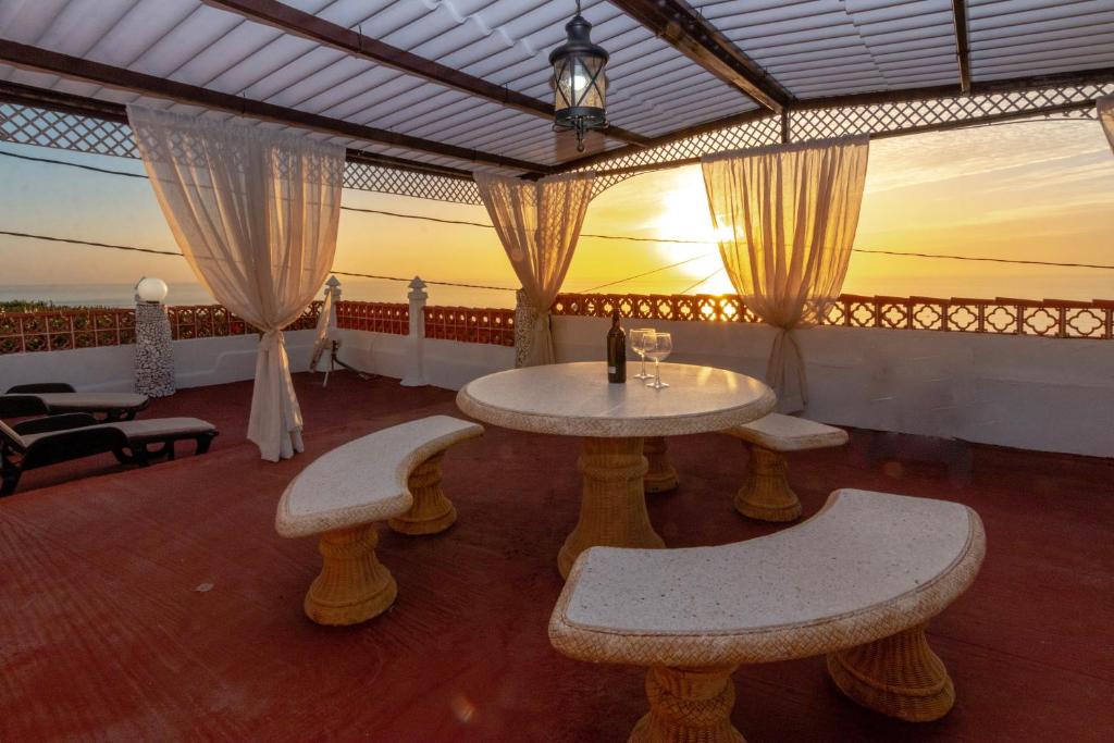 Casa Cucú في Puerto: طاولة وكراسي في غرفة مطلة على المحيط