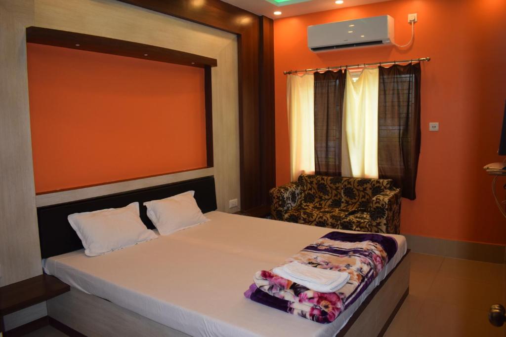 a small bedroom with a bed and a chair at The Imperial Hotel in Rādhākishorepur