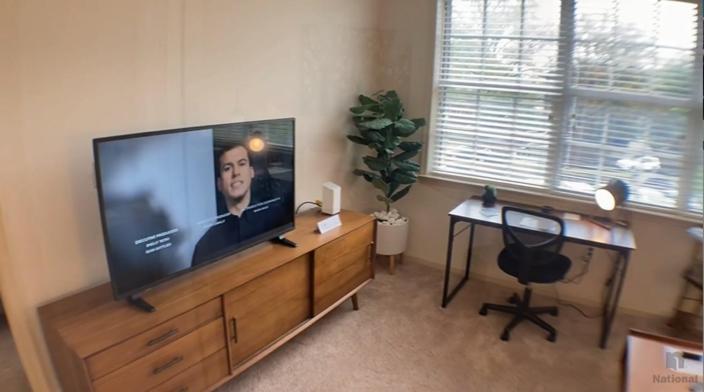 uma sala de estar com uma grande televisão de ecrã plano num centro de entretenimento em madeira em National at Clarendon em Arlington