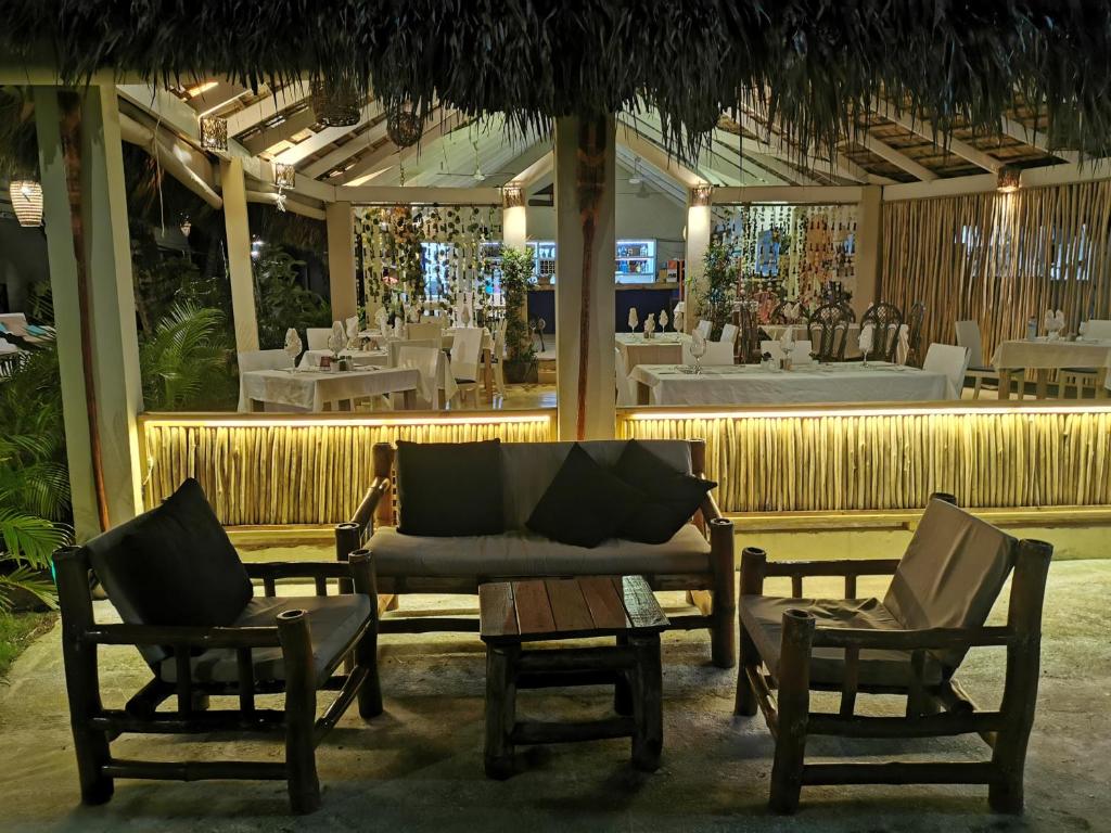 een restaurant met 2 stoelen en een bank en tafels bij Casa Grande Hotel Restaurant in Las Terrenas