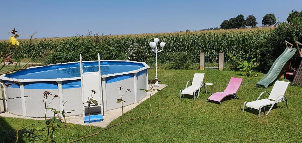 a gazebo with chairs and a slide in a yard at Maison de vacances piscine proche Strasbourg et Europa park in Sand