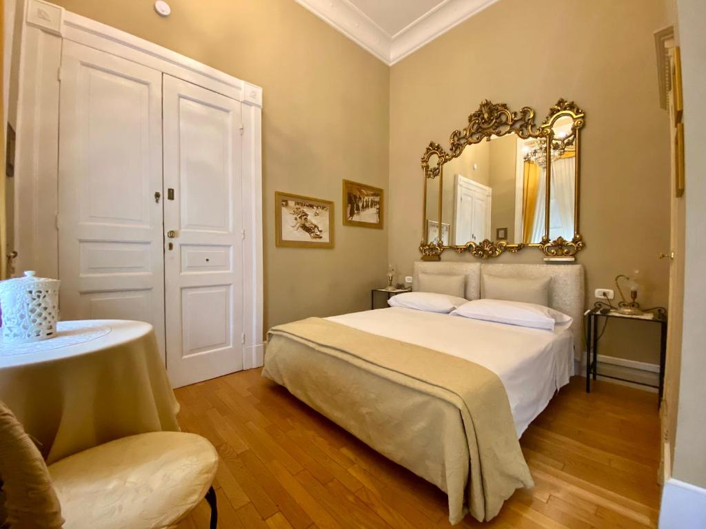 una camera da letto con un letto con uno specchio sul muro di Monfort Club B&B a Campobasso