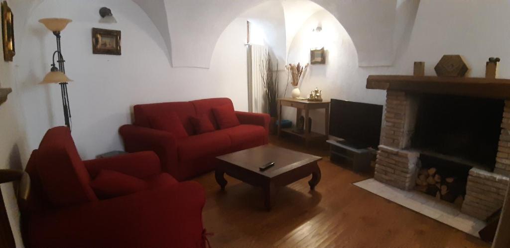 a living room with two red chairs and a fireplace at Legacy Scanno in Scanno