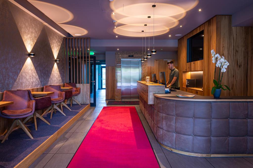 a red carpet in a restaurant with a bar at Kb Hotel in Nersingen