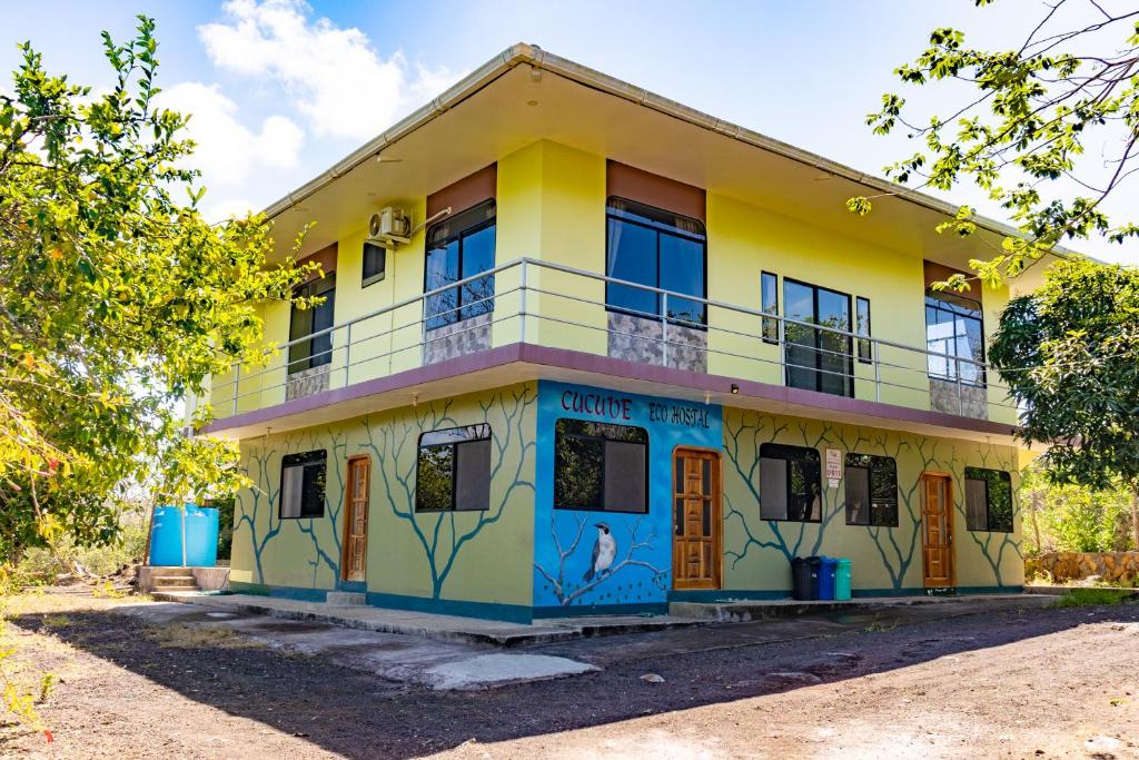 un edificio giallo e blu con graffiti sopra di Cucuve Eco Hostal a Puerto Baquerizo Moreno