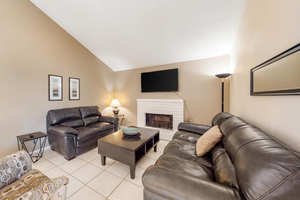 a living room with leather furniture and a fireplace at Indio Desert Diamond Permit# 50842 in Indio