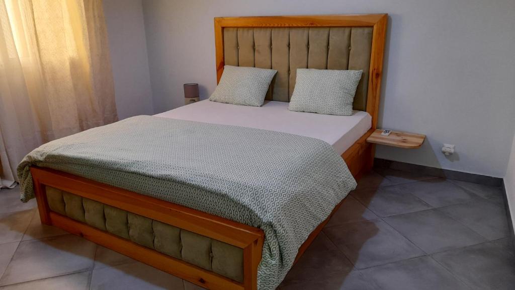 um quarto com uma cama e uma cabeceira em madeira em Nalabba em Dakar