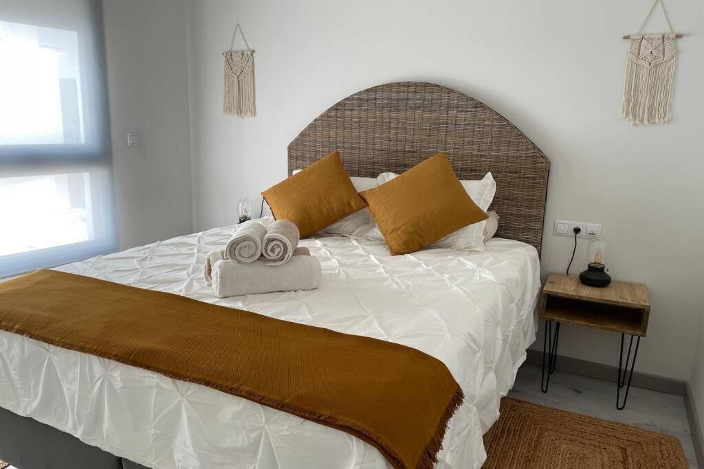 a bedroom with a large bed with two towels on it at Apartamento de lujo con piscina en Tarifa in Tarifa