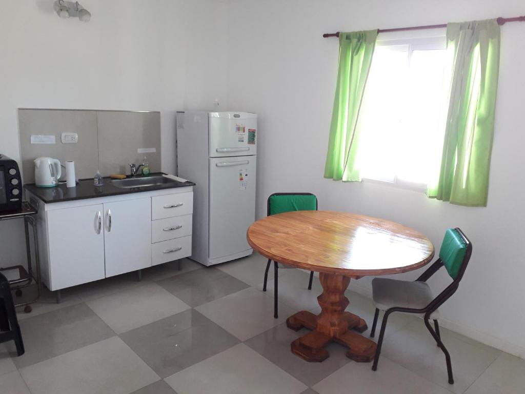 Una cocina con una mesa de madera y una mesa y sillas. en Rita, en Concepción del Uruguay
