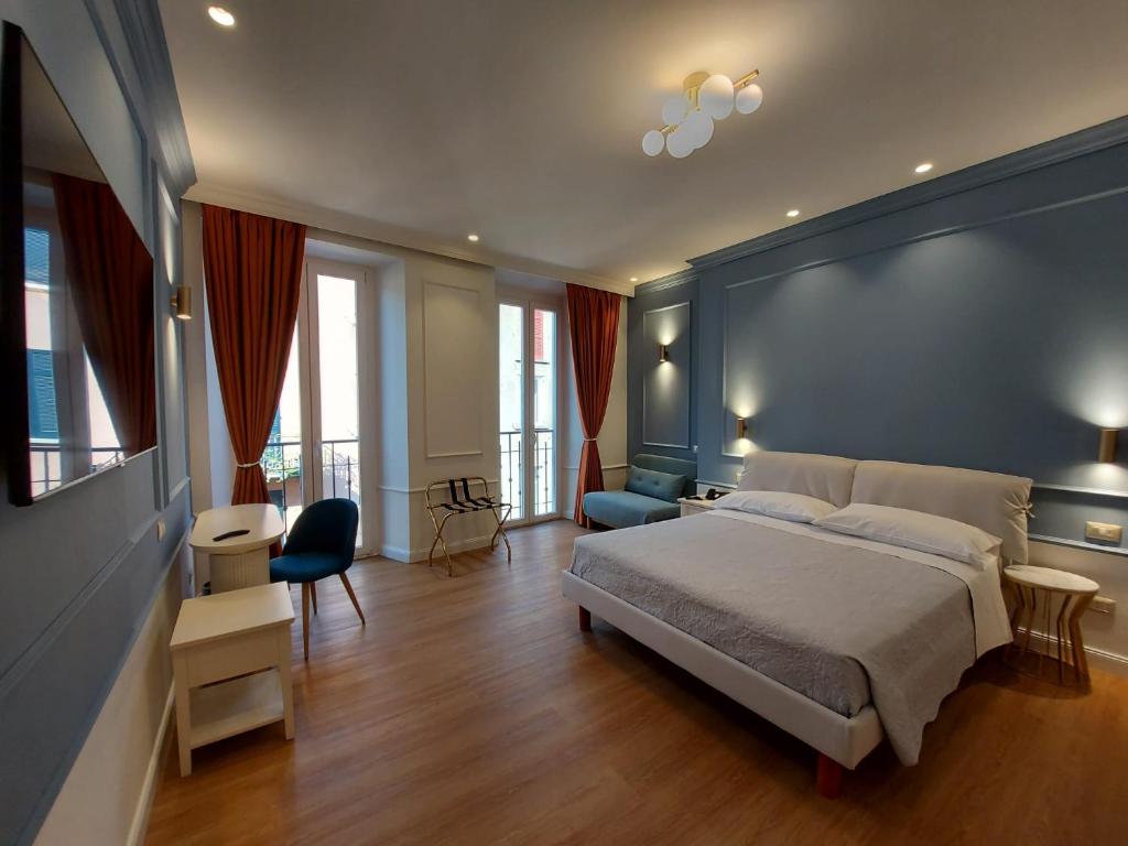una camera con un grande letto e una parete blu di Hotel Borgovico a Como
