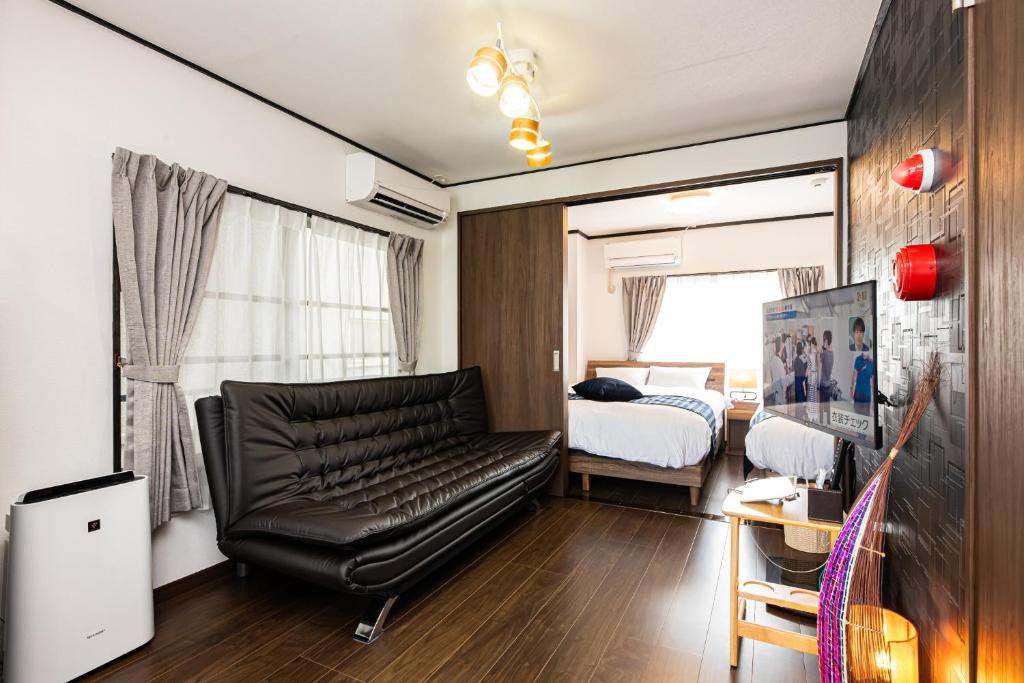 sala de estar con sofá de cuero y cama en Vacation Rental NISHIDA - Vacation STAY 61687v en Kagoshima