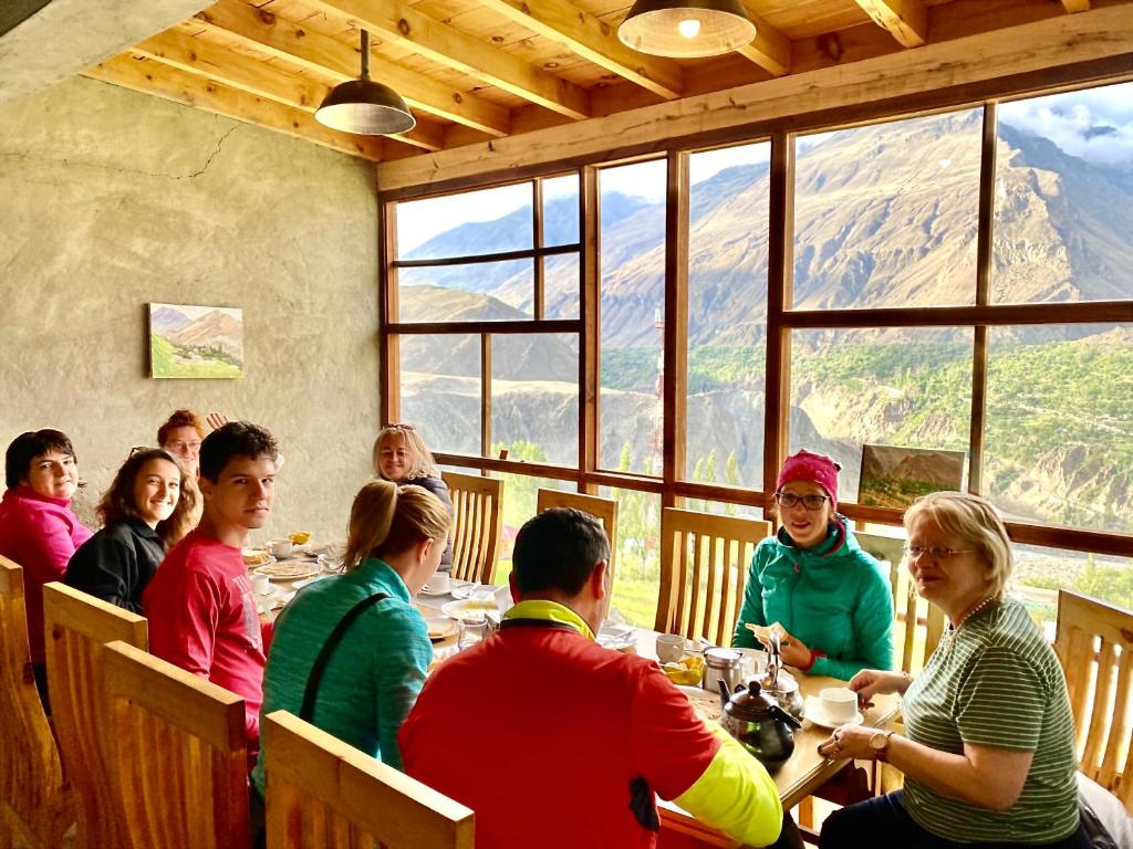 um grupo de pessoas sentadas numa mesa num restaurante em Old Hunza inn em Hunza