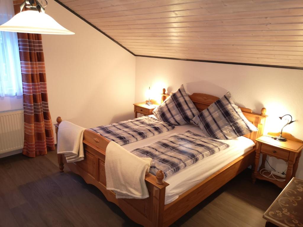 a bedroom with a wooden bed with two night stands at Ferienwohnung - Haus Monika in Philippsreut
