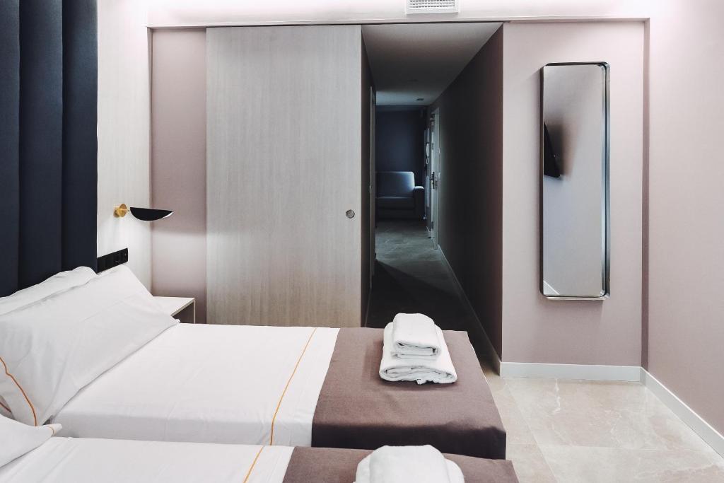 a hotel room with two beds and a mirror at GBH Hotel-Apartamentos Estrella de Mar in Benidorm