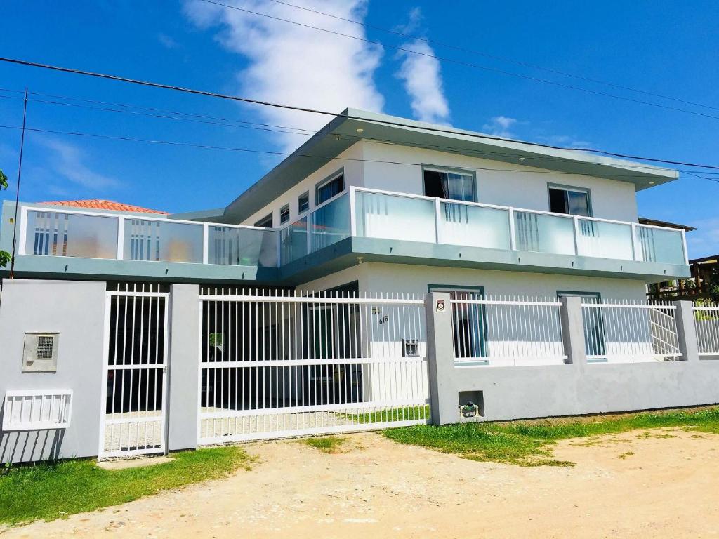 una casa blanca con una valla blanca en Pousada Souza, en Florianópolis