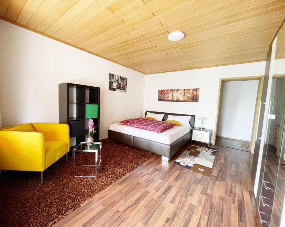 ein Schlafzimmer mit einem Bett und einem gelben Stuhl in der Unterkunft FeWo Royal & Goodness Home in Mühlhausen