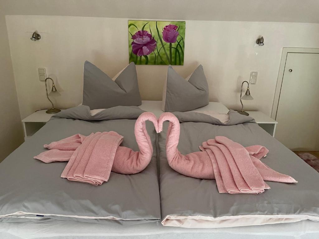 2 asciugamani rosa per fenicotteri sono su un letto di Marina Beach Lauenburg a Lauenburg/Elbe
