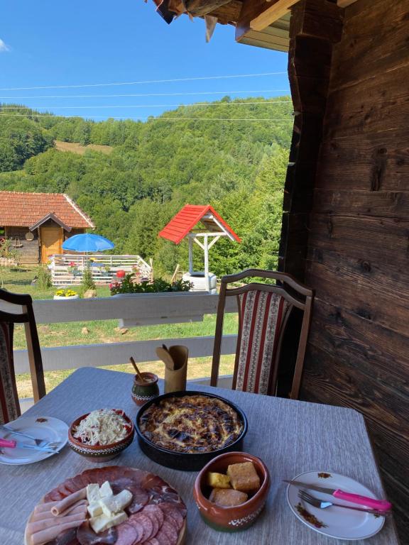 a table with food on it with a view of a mountain at Etno selo Raković in Ivanjica