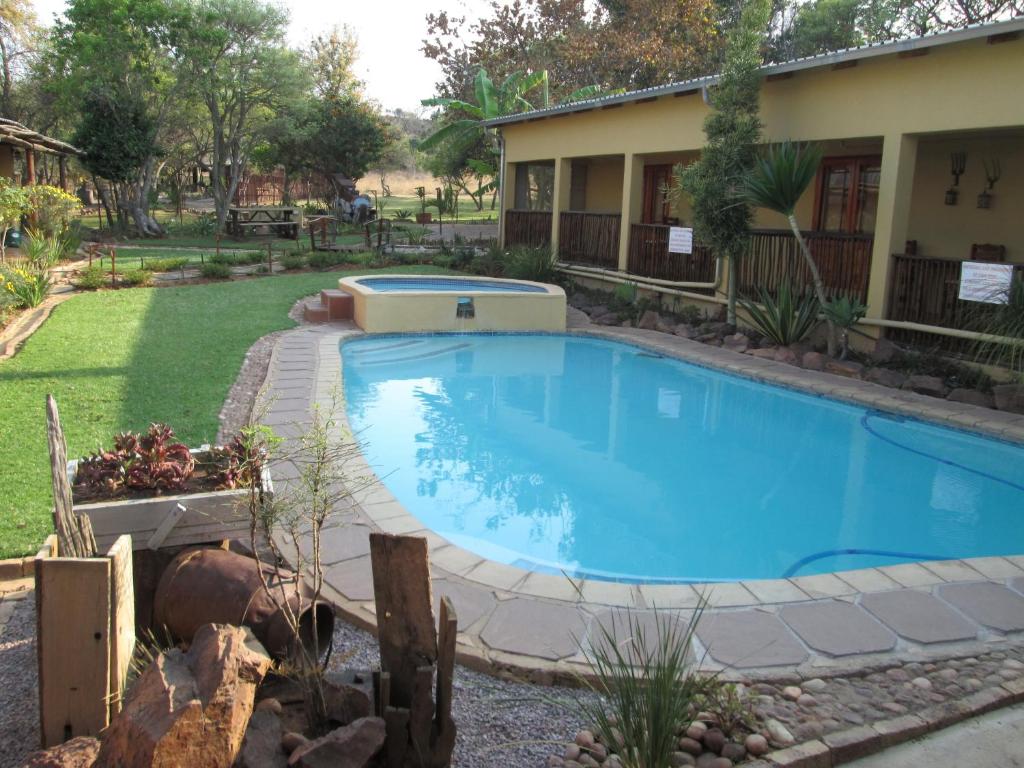 a swimming pool in the yard of a house at Mon Repos Guest Farm in Bela-Bela