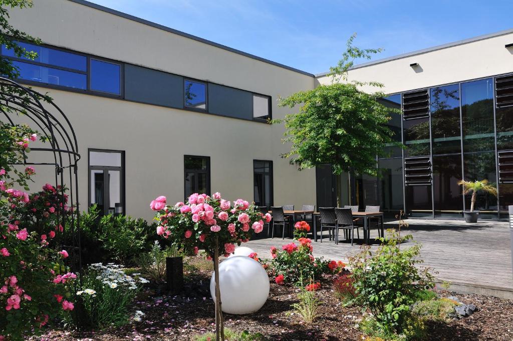 a building with a bunch of flowers in a garden at Sporthotel Borussia Düsseldorf in Düsseldorf