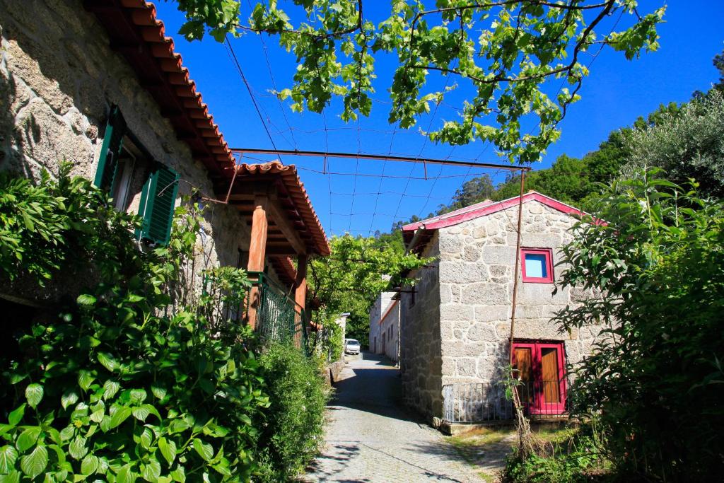 an alley in a small village with a red door at Aldeia Turistica de Louredo in Vieira do Minho