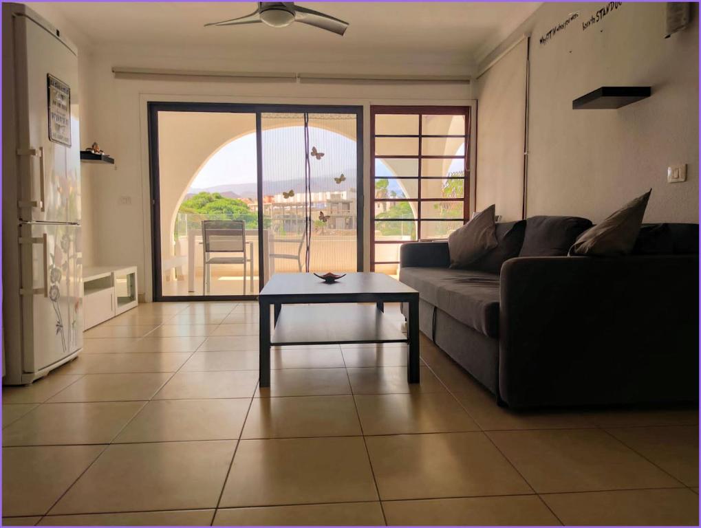 a living room with a couch and a table at Pebble beach apartamento, Amarilla golf in San Miguel de Abona