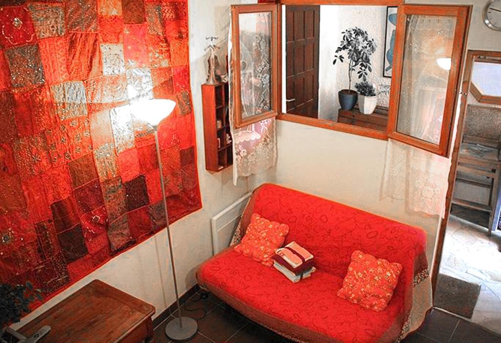 un sofá rojo con 2 almohadas en una habitación en Adorable Studette Nice Cessole, en Niza