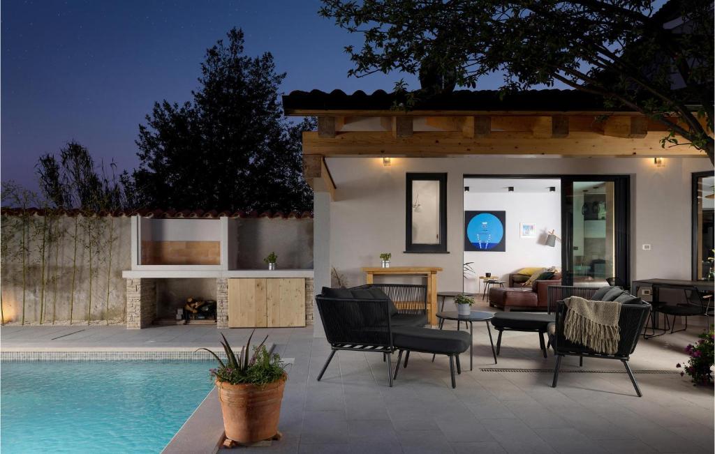 a patio with chairs and a swimming pool at night at Stunning Home In Medulin With Wifi in Medulin