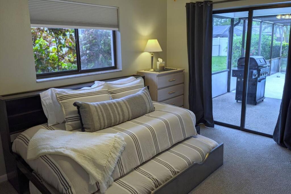 um quarto com uma cama, um sofá e uma janela em The Max em Cape Coral
