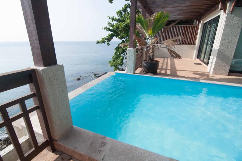 a swimming pool with a view of the ocean at Penn Sunset Villa 10 with Shared Pool in Ko Lanta